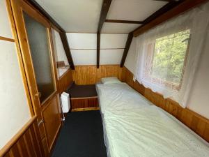 a small room with two beds and a window at Chata na Cihelně in Nové Město na Moravě