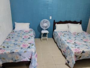 1 dormitorio con 2 camas y ventilador en Apartamento cercado por natureza e diversão, en Maceió
