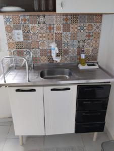 a kitchen with a sink and a counter top at Apartamento cercado por natureza e diversão in Maceió