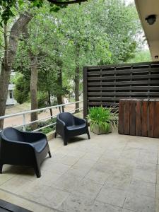 un patio con 2 sedie nere e una recinzione di Terrazas de Carilo 1C a Carilo