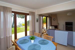a dining room with a blue table and chairs at Beachfront Villa Possidi by Halkidiki Villas in Possidi