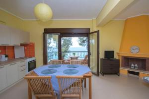 a kitchen with a table and chairs and a kitchen with a view at Beachfront Villa Possidi by Halkidiki Villas in Possidi