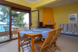 a dining room with a table and chairs and a balcony at Beachfront Villa Possidi by Halkidiki Villas in Possidi