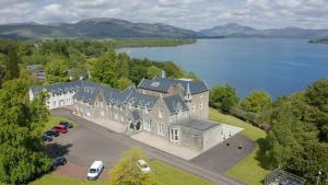 an aerial view of a large house by the water at Benoch Lomond Castle in Alexandria