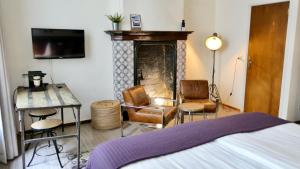 a bedroom with a fireplace and a bed and chairs at BE41 Boutique Hotel in Maastricht
