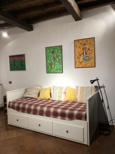 Bett in einem Zimmer mit Gemälden an der Wand in der Unterkunft Verso Sud in Sutri