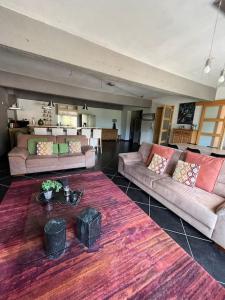a large living room with two couches and a kitchen at Loft spacieux dans une ancienne beurrerie avec parking gratuit in Theux