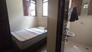 - une petite chambre avec un lit et un lavabo dans l'établissement Casa do Uai, à João Pessoa