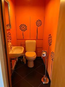 an orange bathroom with a toilet and a sink at Loft spacieux dans une ancienne beurrerie avec parking gratuit in Theux