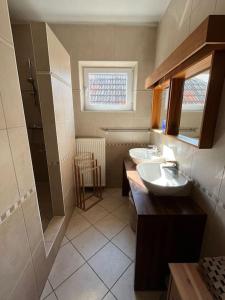 a small bathroom with two sinks and a window at Loft spacieux dans une ancienne beurrerie avec parking gratuit in Theux
