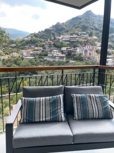 ein Sofa auf einem Balkon mit Stadtblick in der Unterkunft Balkoni Moutoullas in Moutoullas