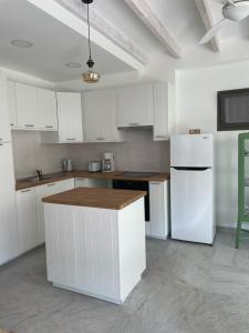 eine Küche mit weißen Schränken und einem weißen Kühlschrank in der Unterkunft Balkoni Moutoullas in Moutoullas