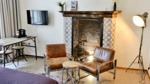 a living room with two chairs and a fireplace at BE41 Boutique Hotel in Maastricht