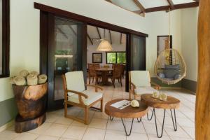 ein Wohnzimmer mit Stühlen und einem Tisch in der Unterkunft Cala Luna Boutique Hotel & Villas in Tamarindo