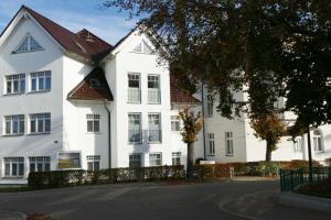 un edificio blanco con techo rojo en Schloss Hohenzollern - Wohnung 03, en Ahlbeck