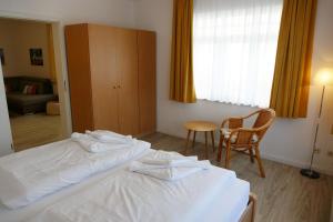 una habitación de hotel con 2 camas y una silla en Schloss Hohenzollern - Wohnung 03, en Ahlbeck
