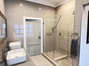 a bathroom with a glass shower and a sink at Sasavona Cottage - 349 Vaal de Grace Golf Estate in Parys +48 photos