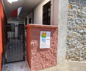 a brick wall with a sign in front of a building at B&B Tra Monti e Mare in Ogliastro Cilento