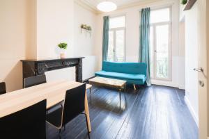 a living room with a blue couch and a table at The National Street Residence in Antwerp