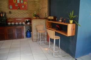a kitchen with a counter and stools in a room at Pousada La Luna in Paracuru +85 photos