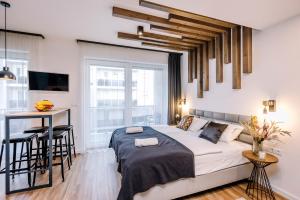 1 dormitorio con cama, mesa y escritorio en Amade Apartments en Győr
