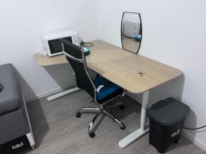 an office with a desk with a computer and a chair at Chambre individuelle dans un appartement à 37 de champs élysées in Sartrouville
