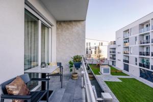Apartamento con balcón con mesa y sillas. en Amade Apartments, en Győr
