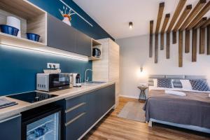 a kitchen and living room with a bed in a room at Amade Apartments in Győr