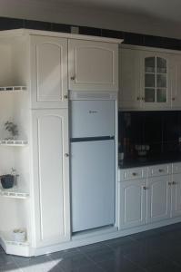 uma cozinha com armários brancos e um frigorífico branco em Centro da cidade Amarante em Amarante