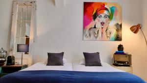 1 dormitorio con 1 cama con una pintura en la pared en BE41 Boutique Hotel, en Maastricht