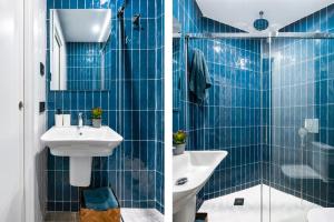 La salle de bains est pourvue de carrelage bleu, d'un lavabo et d'une douche. dans l'établissement Avanti Azahar, en un barrio con encanto, à Séville