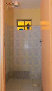 a bathroom with a shower with a window at Cool and Calm Homes in Homa Bay