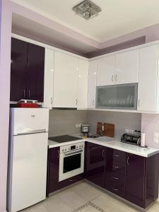 a kitchen with white appliances and purple cabinets at Piraeus Cozy in Piraeus