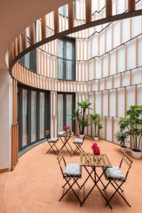 un patio avec des chaises et des tables dans un bâtiment dans l'établissement Avanti Azahar, en un barrio con encanto, à Séville