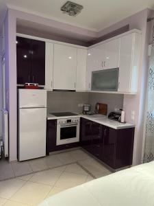 a kitchen with white cabinets and a stove top oven at Piraeus Cozy in Piraeus