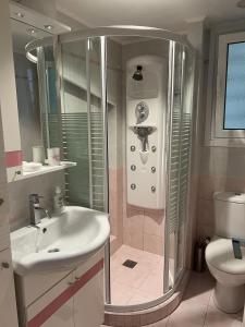 een badkamer met een douche, een wastafel en een toilet bij Piraeus Cozy in Piraeus