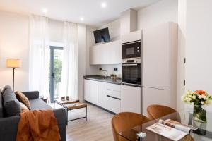 eine Küche mit weißen Schränken und ein Wohnzimmer in der Unterkunft Avanti Buganvilla, la Sevilla auténtica in Sevilla