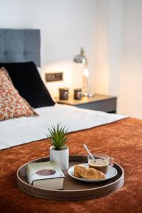 ein Tablett mit einem Teller Essen auf dem Bett in der Unterkunft Avanti Buganvilla, la Sevilla auténtica in Sevilla