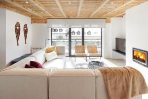 a living room with a white couch and a tv at Inuit by FeelFree Rentals in Vielha