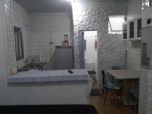 uma pequena cozinha com um lavatório e uma bancada em Recanto em Mongaguá