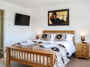 a bedroom with a bed and a flat screen tv at The Byre Camp Douglas in Crossmichael