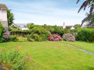 a garden with a lawn and flowers in a yard at Stonehanger 1 in Salcombe
