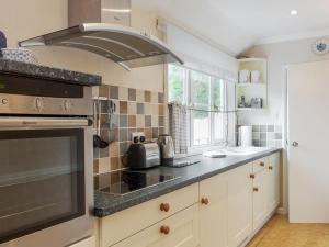 a kitchen with a stove top oven next to a window at St Elmo Lodge in Salcombe