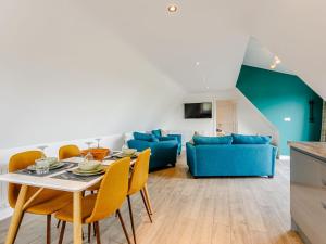 a living room with a table and chairs and a couch at Home Farm Lodge in Baston