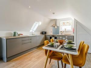 uma cozinha e sala de jantar com mesa e cadeiras em Home Farm Lodge em Baston