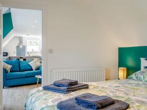 a bedroom with a bed and a blue couch at Home Farm Lodge in Baston