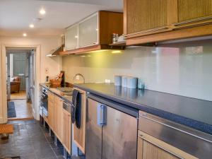 a kitchen with stainless steel appliances and wooden cabinets at Fox Cottage in Beverley