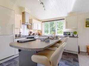 a kitchen with a large island in a kitchen with white cabinets at Bryn Teg in Maesmynis