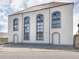 a white building with large windows on a street at Heron Apartment in Berwick-Upon-Tweed