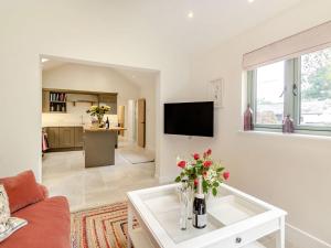 a living room with a couch and a tv at Church Garden Cottage in Higham
